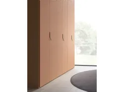 Swing door wardrobe with smooth door, interior in oak, doors in matte lacquered copper.